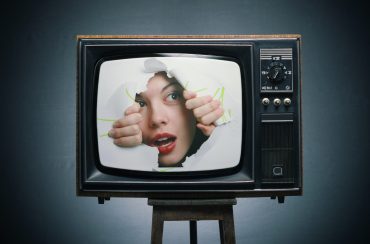 TV with a picture of a girl, his eyes through the hole.