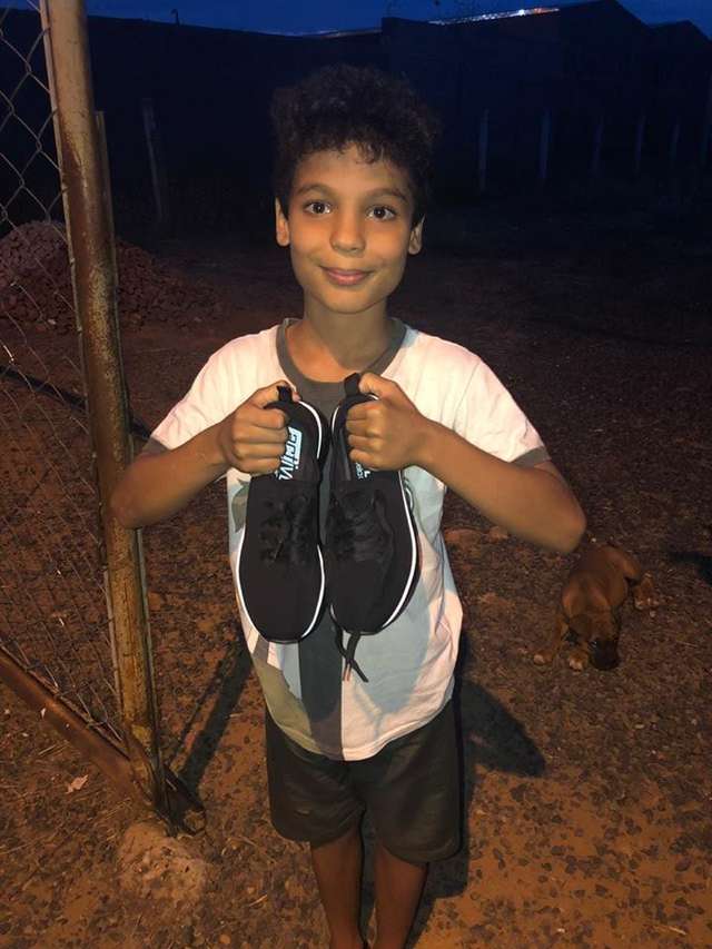 мальчик держит обувь в руках