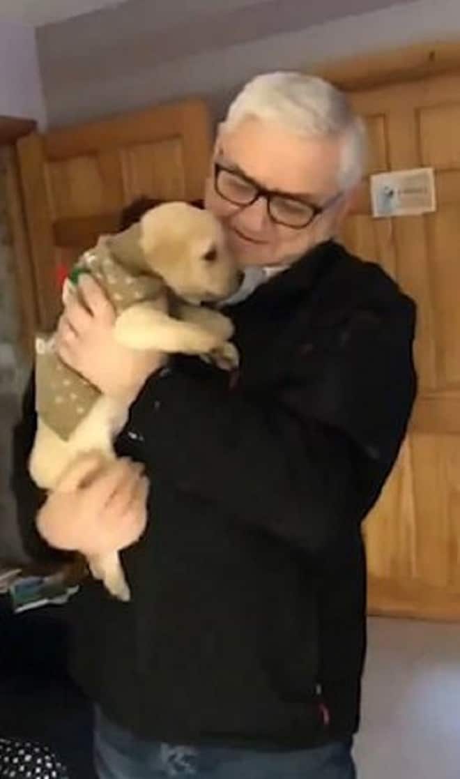 Дедушка держит щенка