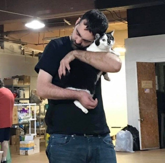Мужчина обнимает кота